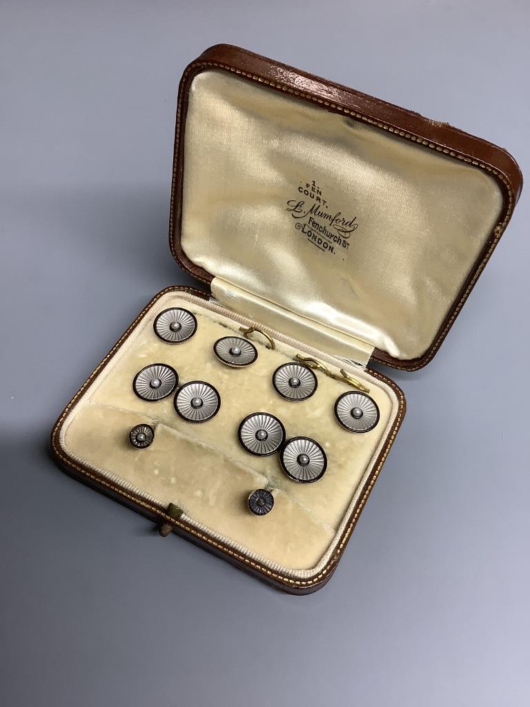 An Edwardian 18ct. gold and platinum, black enamel and pearl, eight piece cuff links, stud and button set, cased